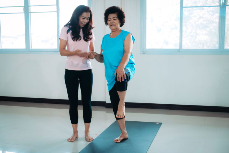 physical therapist assists a patient with balance exercise