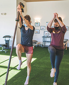 a physical therapist works with a patient on balance and strength training