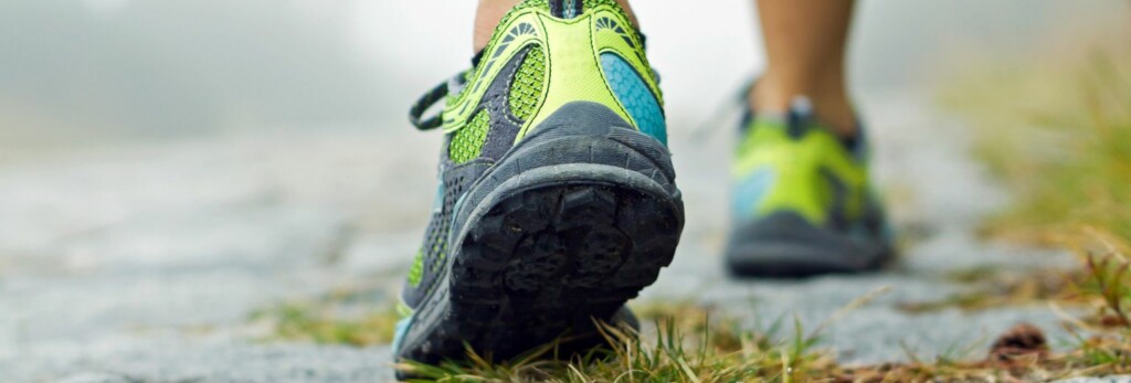 close up image of a person's athletic shoes in walking/running action
