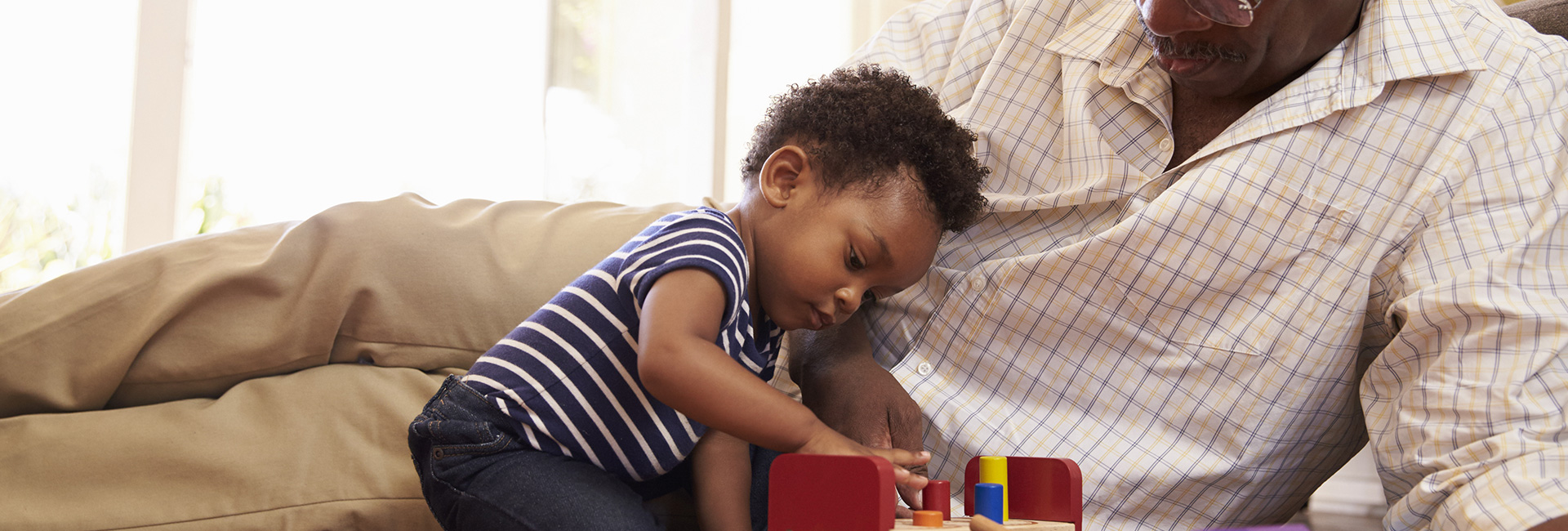 a toddler plays blocks with grandparent