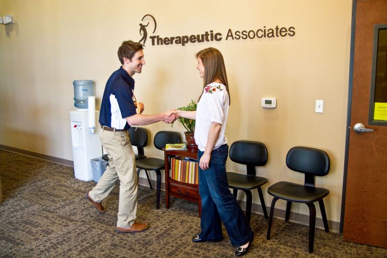 A physical therapist greet a patient.