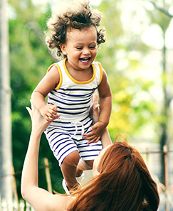 a mom throws her toddler into the air