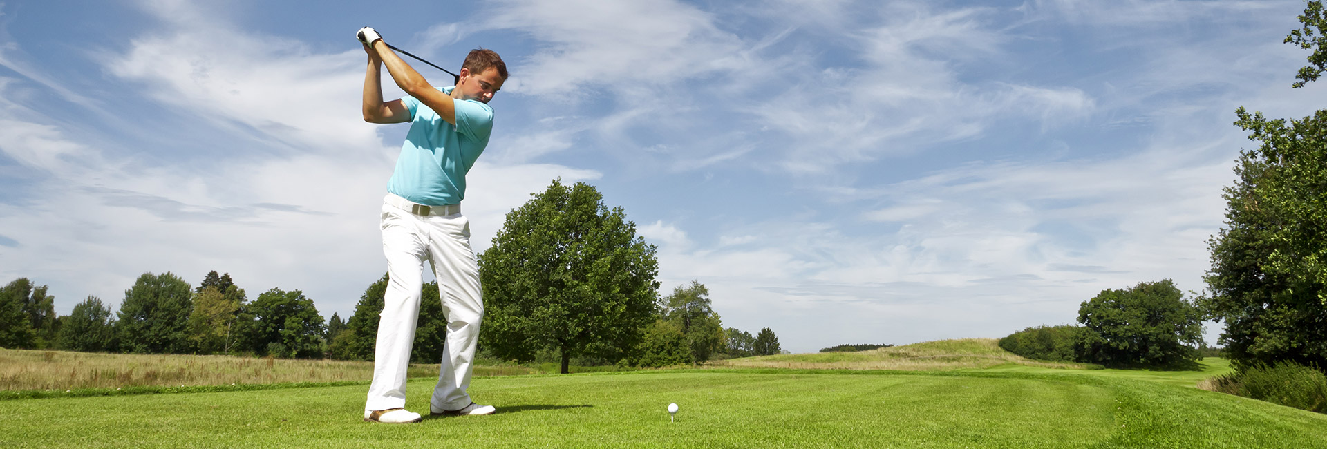 a young golfer mid backswing on the golf course