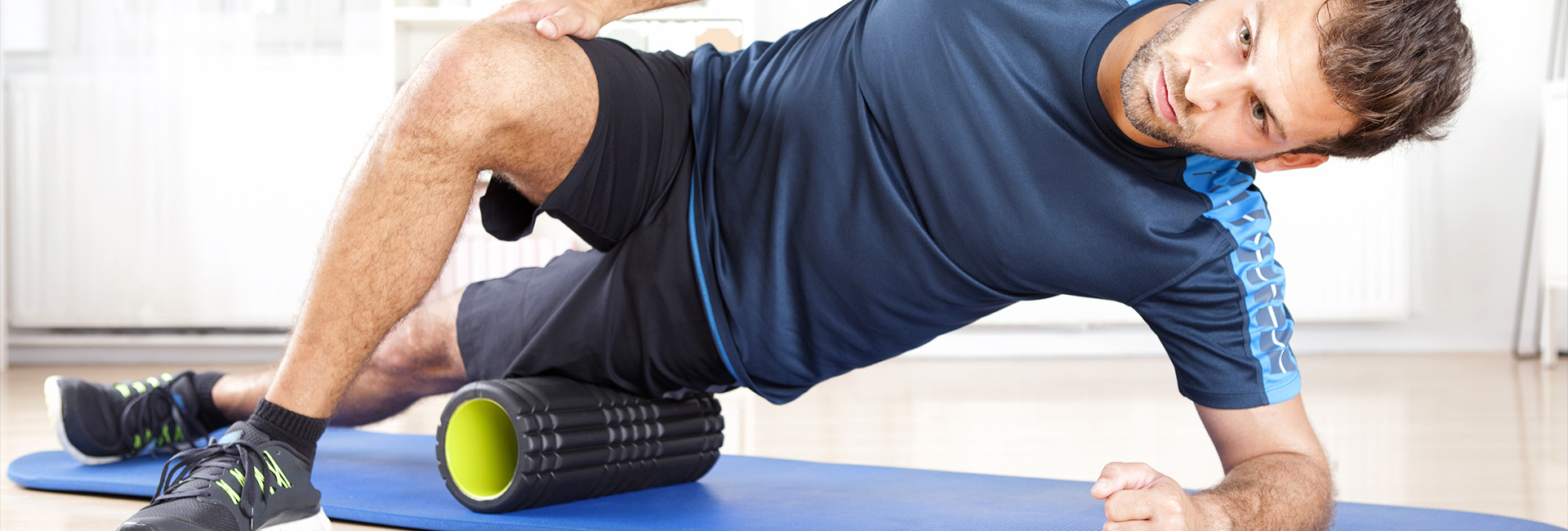 a fit man foam rolling his outside leg