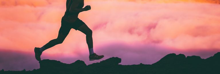 silhouette of a runner with a pink sky behind