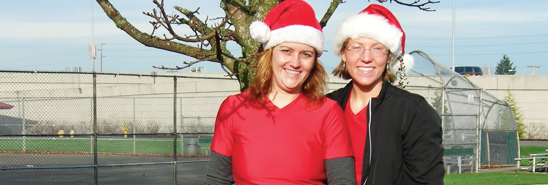 two happy women in Santa hats smile