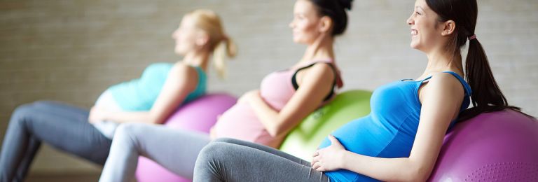 a group of three pregnant women in an exercise class