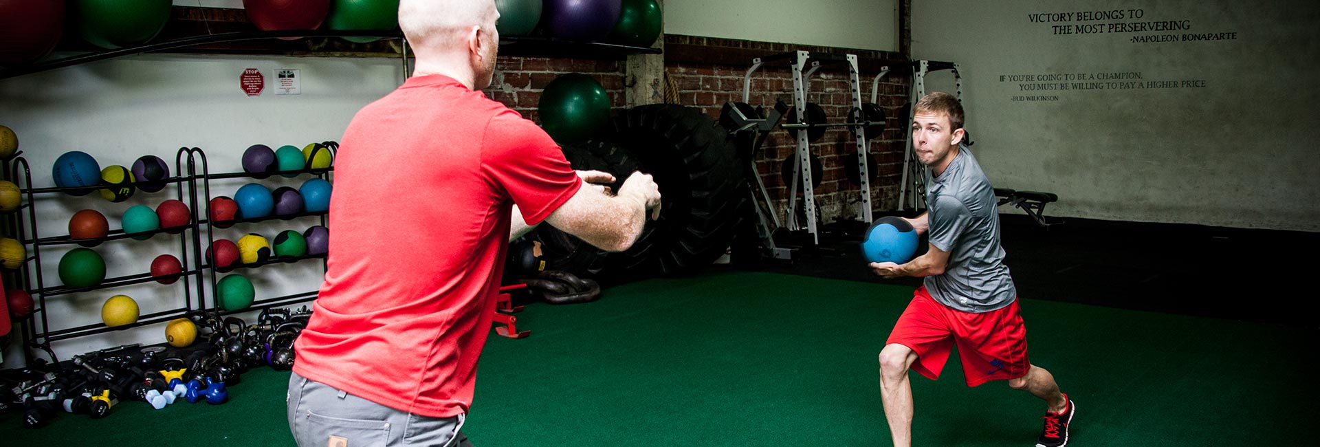 A physical therapist works with a young athlete doing sports specific exercise focused on breathing