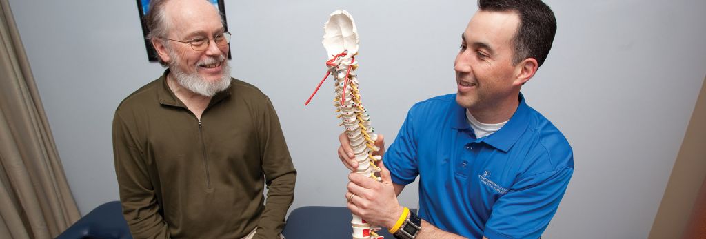 a physical therapist explains a patient's condition to him during shared decision making