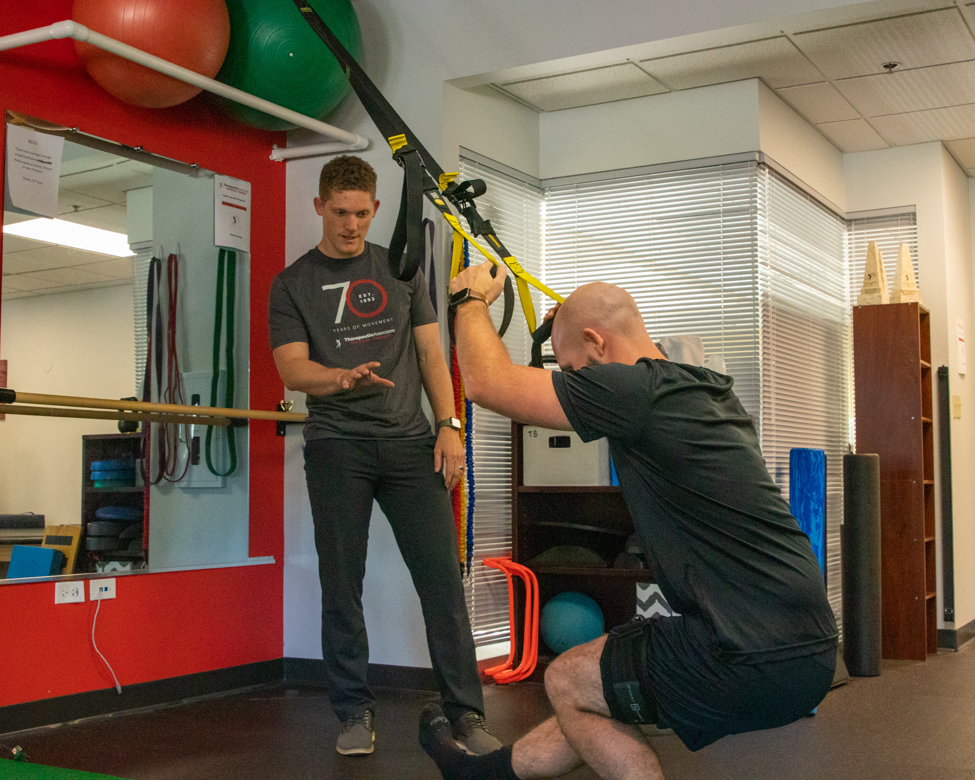 physical therapist works with a patient on exercise in the clinic