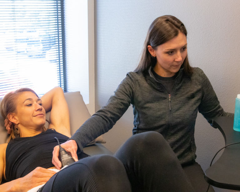 a physical therapist works with ultrasound technology for muscle assessment