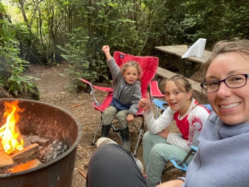 A woman and her two children by the campfire
