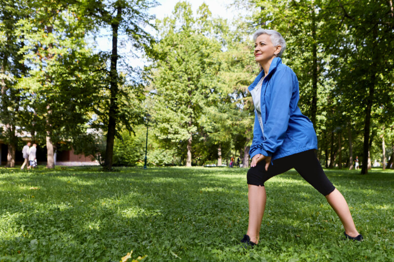 woman stretches in an easy lunch outdoors in a grassy area