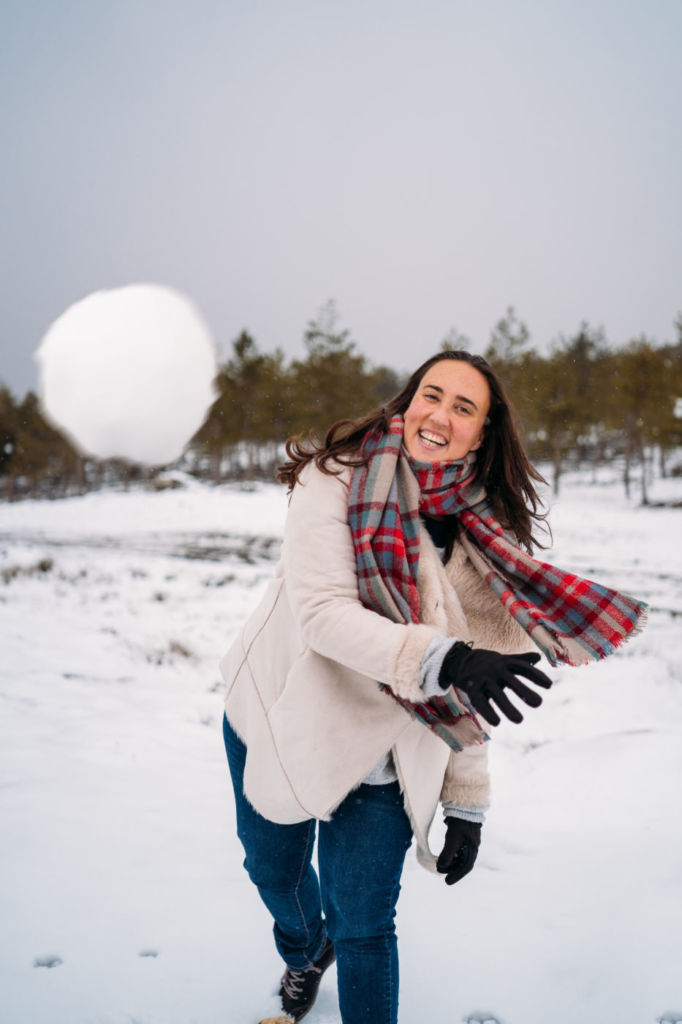 smiling woman throwing snowball