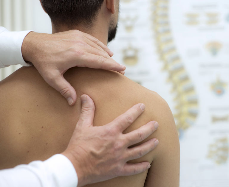 a medical professional works on a patient's shoulder and back