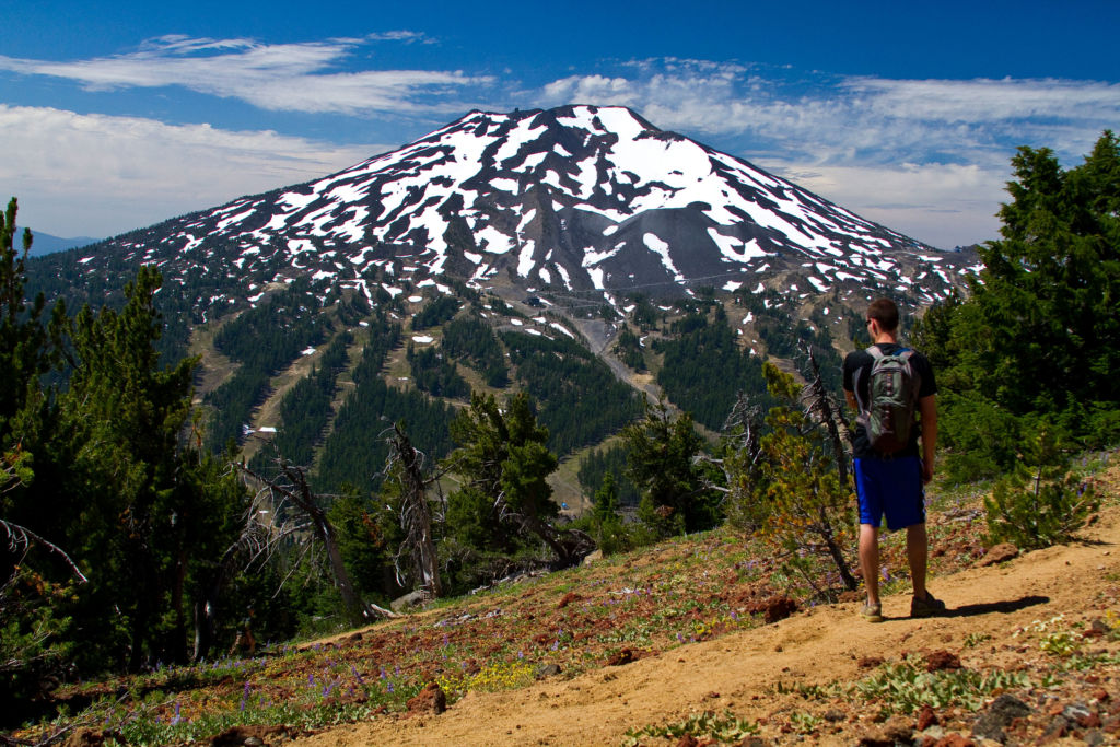 man on a hike on Tumalo mountain with Mount Bachelor in the landscape beyond