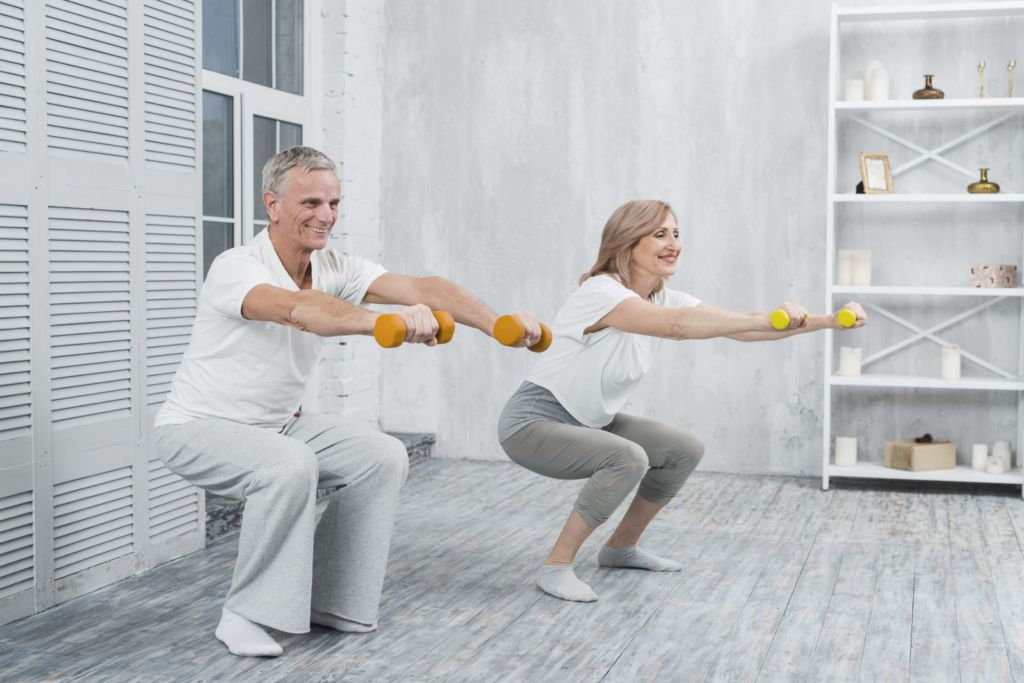 older couple doing dumbbell squat exercise