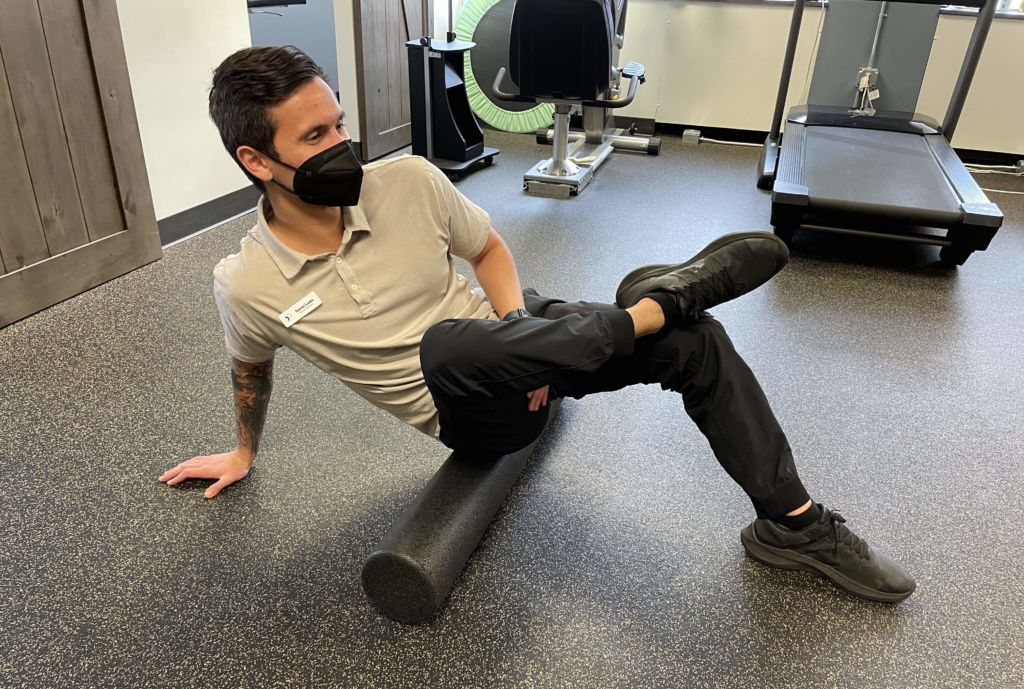 man doing foam rolling exercise called Piriformis Release