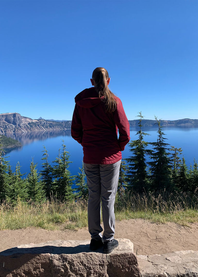 woman overlooks lake on a hike