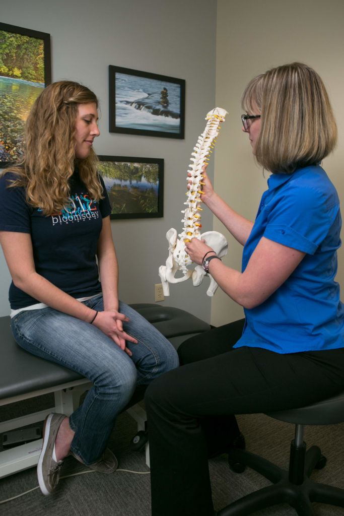 physical therapist educations patient about spinal stenosis