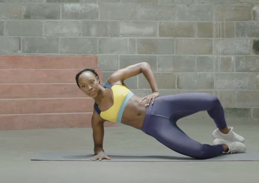 woman demonstrates side plank clamshell