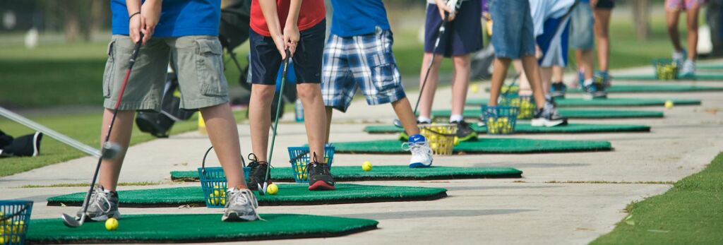 junior golfers lined up to practice