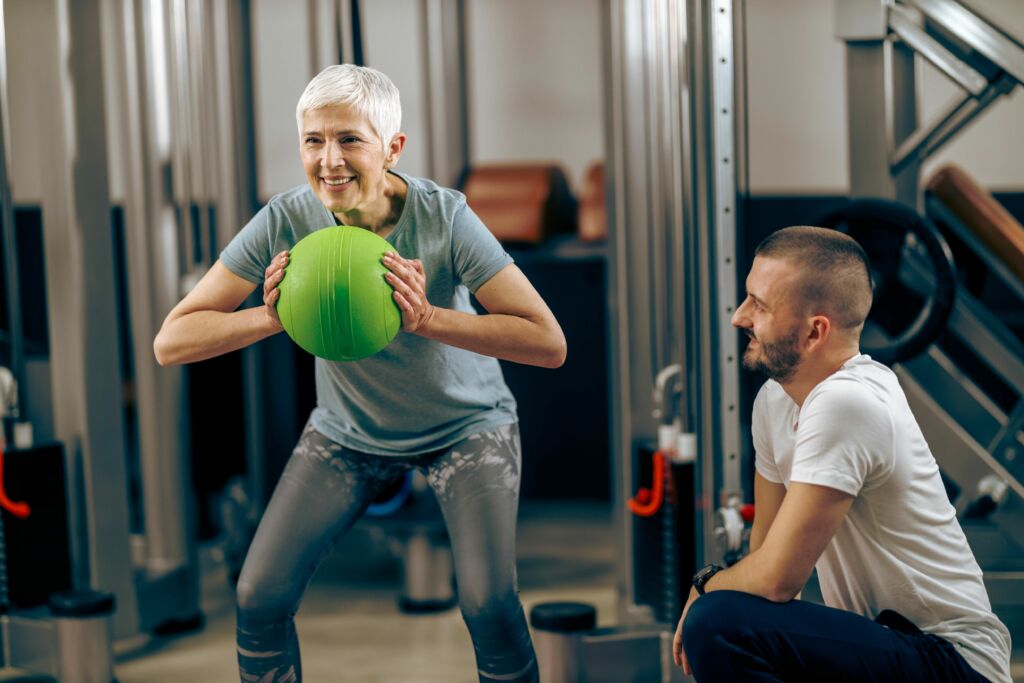 physical therapist coaches a woman on therapeutic exercise in the clinic