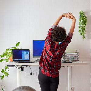 woman stretches by her work station