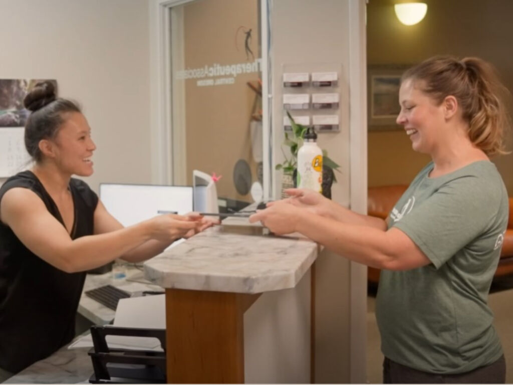 woman checks in to Therapeutic Associates Physical Therapy - Athletic Club of Bend