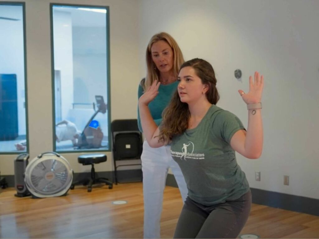 physical therapist guides patient on yoga form