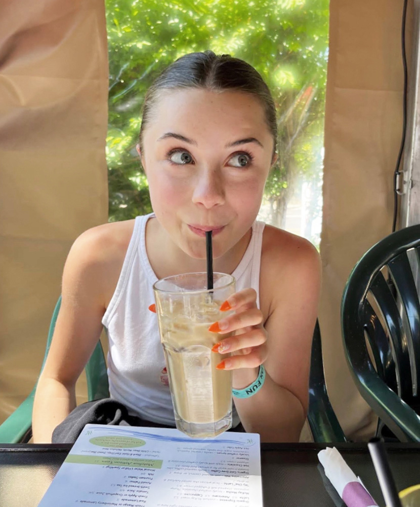 young woman sips a fun summer beverage from a straw
