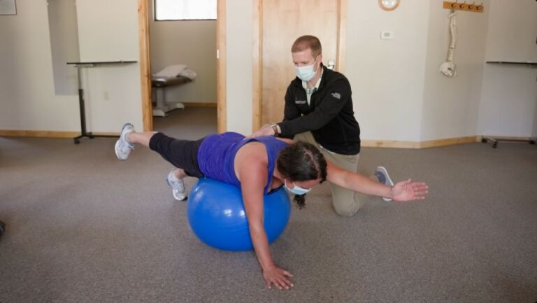physical therapist works with patient for low back pain