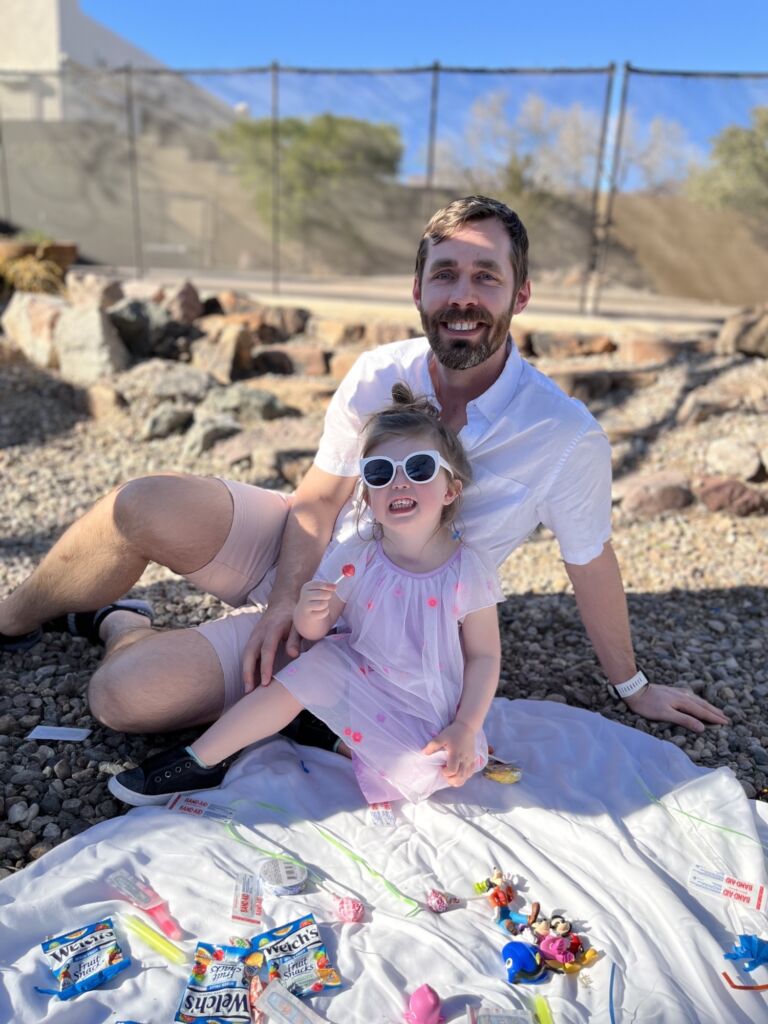 a man and his daughter enjoy a sunny picnic