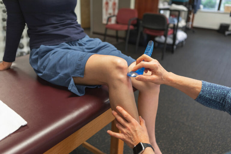 ASTYM manual therapy technique on a patient's knee