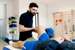 physical therapist works with patient on knee and hip mobility