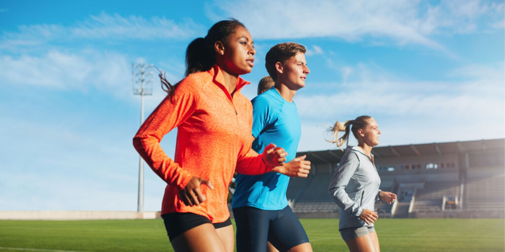 multiracial young athletes training run at school track
