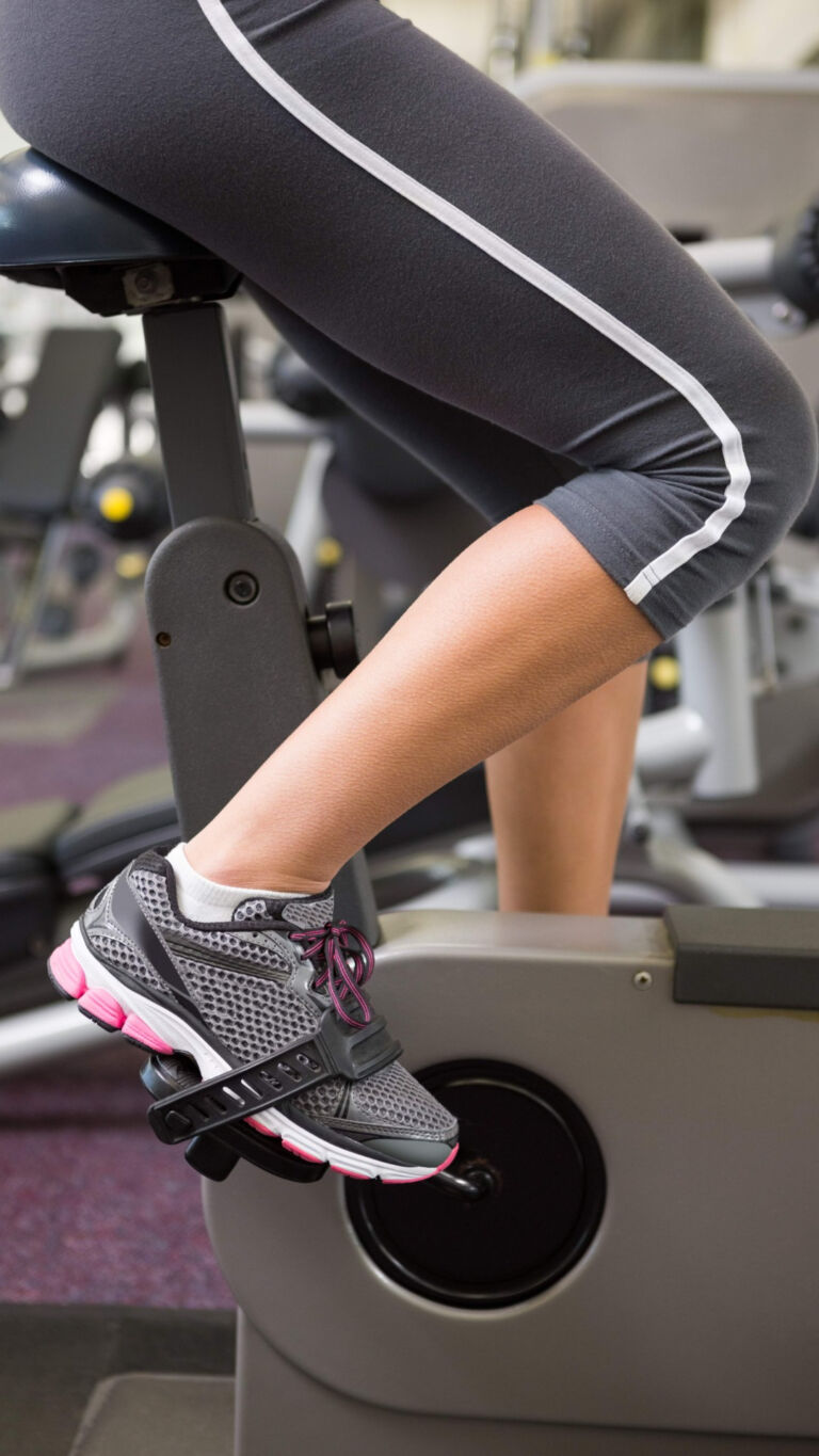 close-up of a woman's legs while working out on a stationary bike