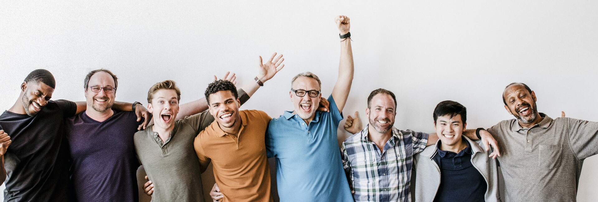 a group of diverse men pose for a happy photo