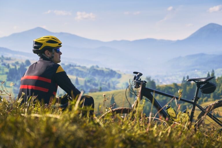 man sits taking in view during a break on a bike ride