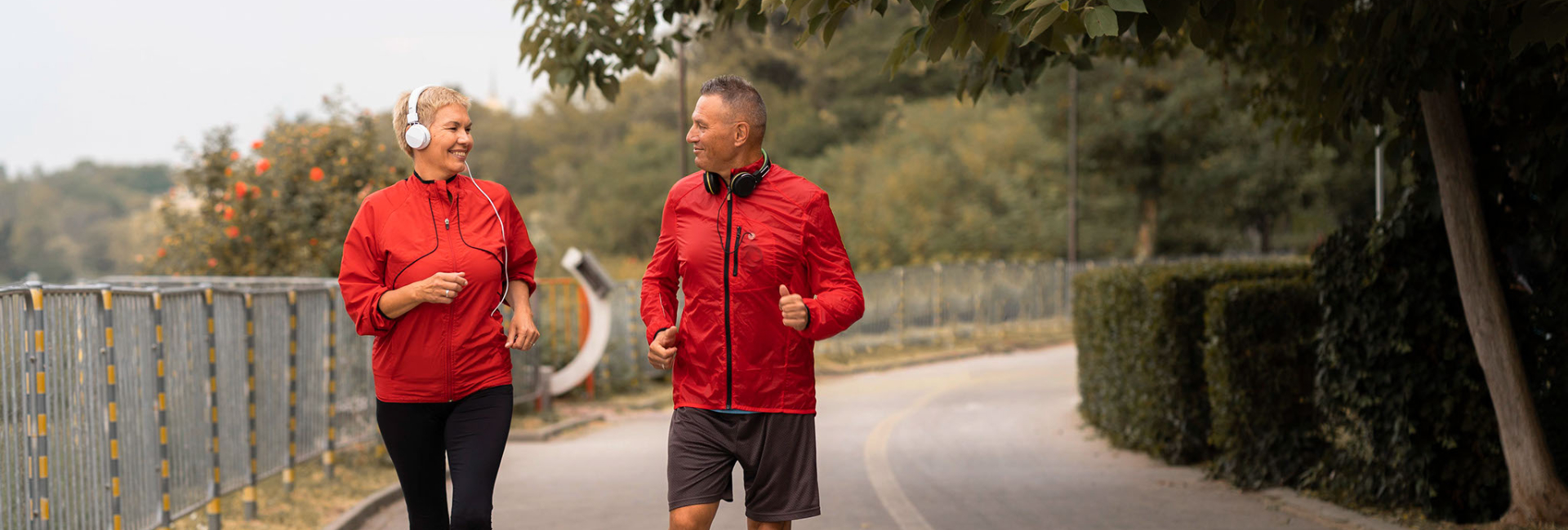 man and woman walk together outside in a park as a form of exercise