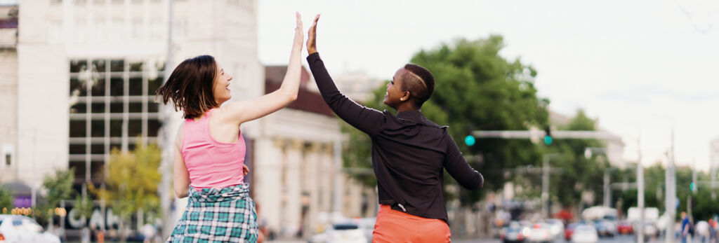 racially diverse friends high-five during a run in the city