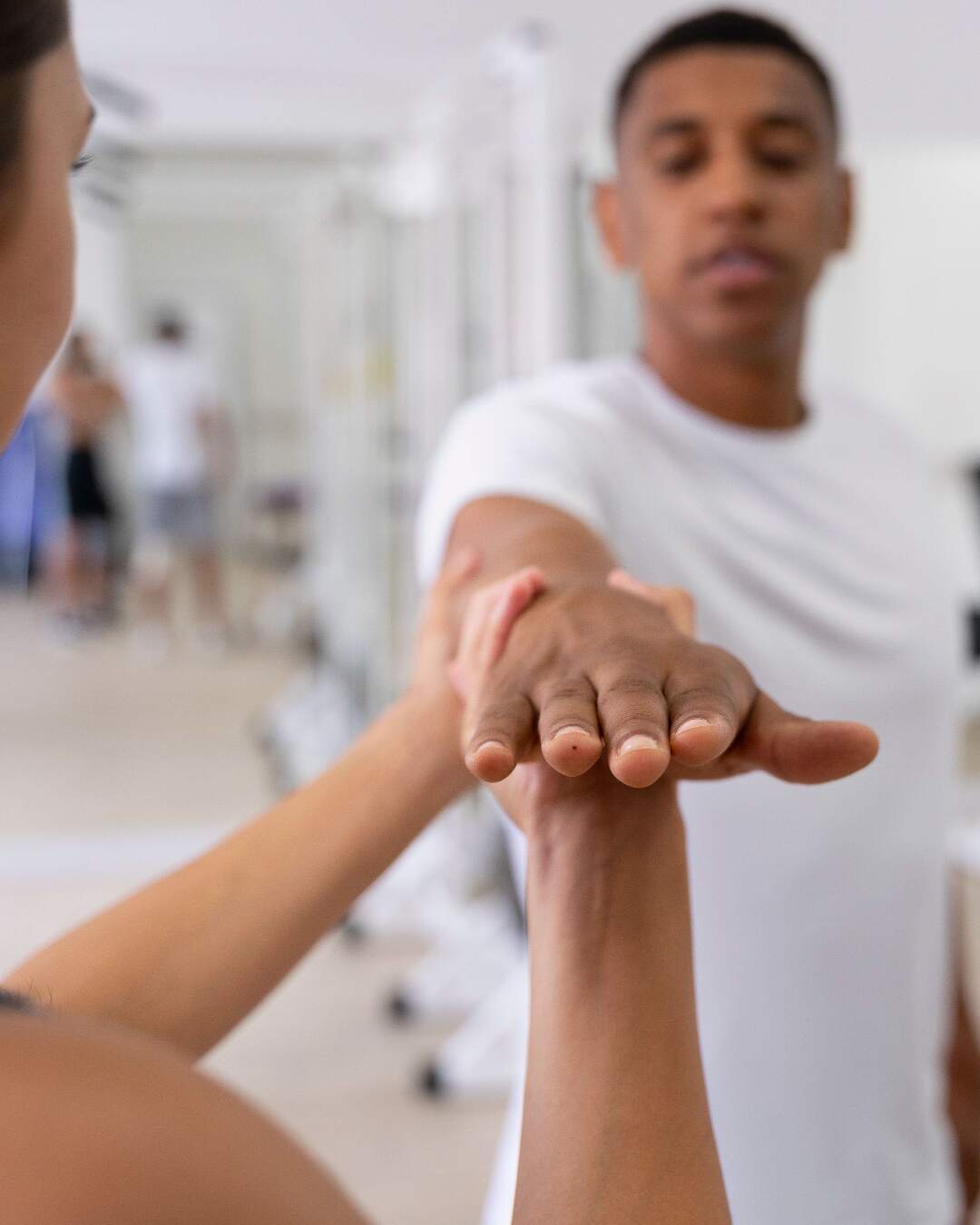 physical therapist works with a patient to assess an injury to the arm and shoulder