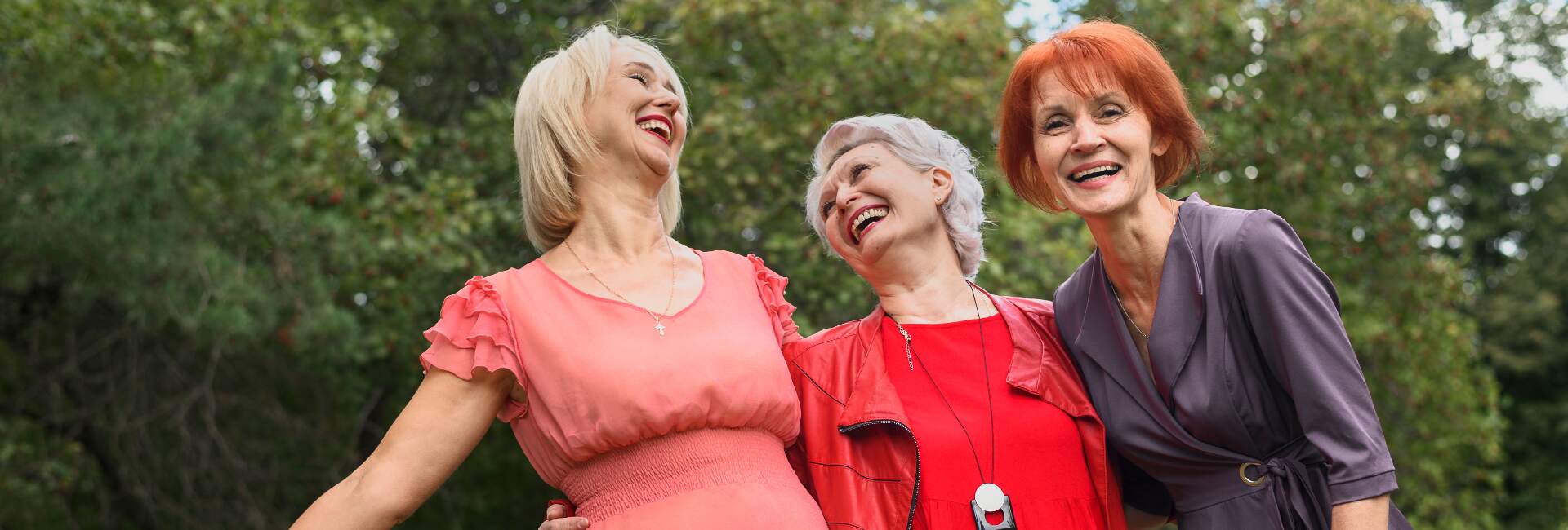 three senior women laugh and enjoy time together outdoors