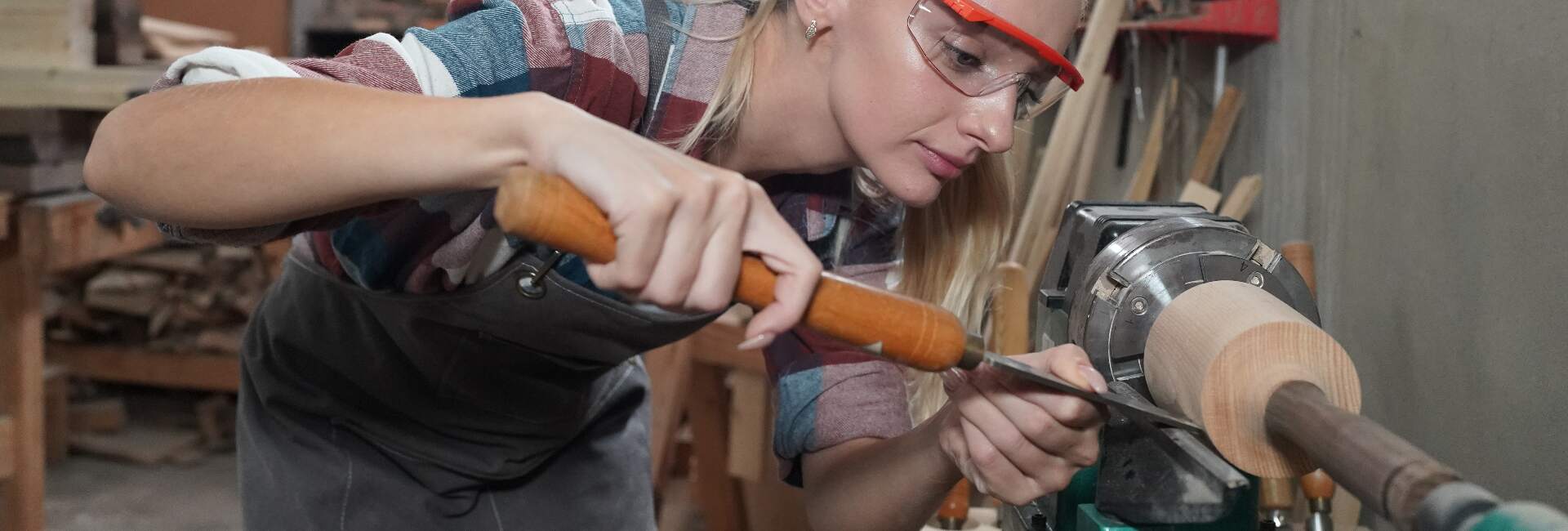 young woman works with tools in DIY woodshop