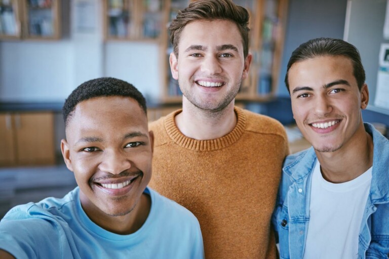 three young people smile for the camera