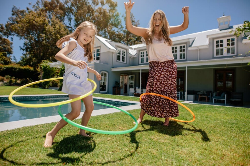 mother and daughter hula hooping on a nice sunny day outside
