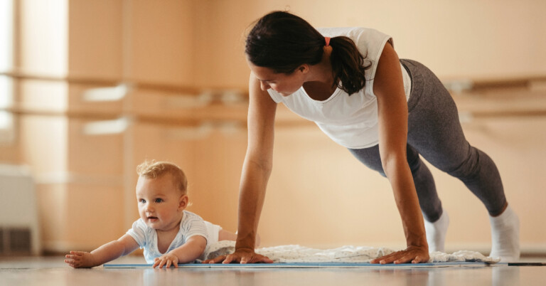 new mother does plank exercise while with baby