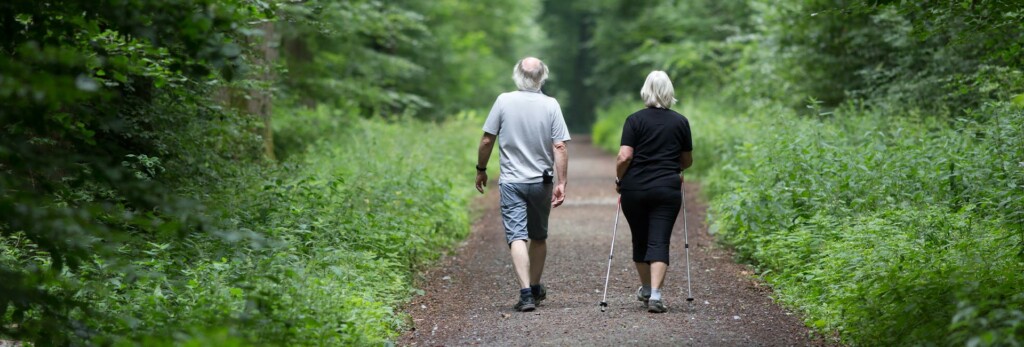 rear view of an older couple walking together practicing good balance