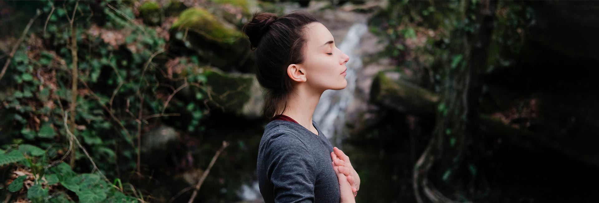 a woman takes time to pay attention to her breathing while outdoors