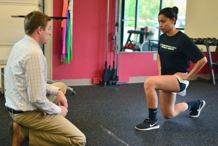 a physical therapist works with a patient doing lunges